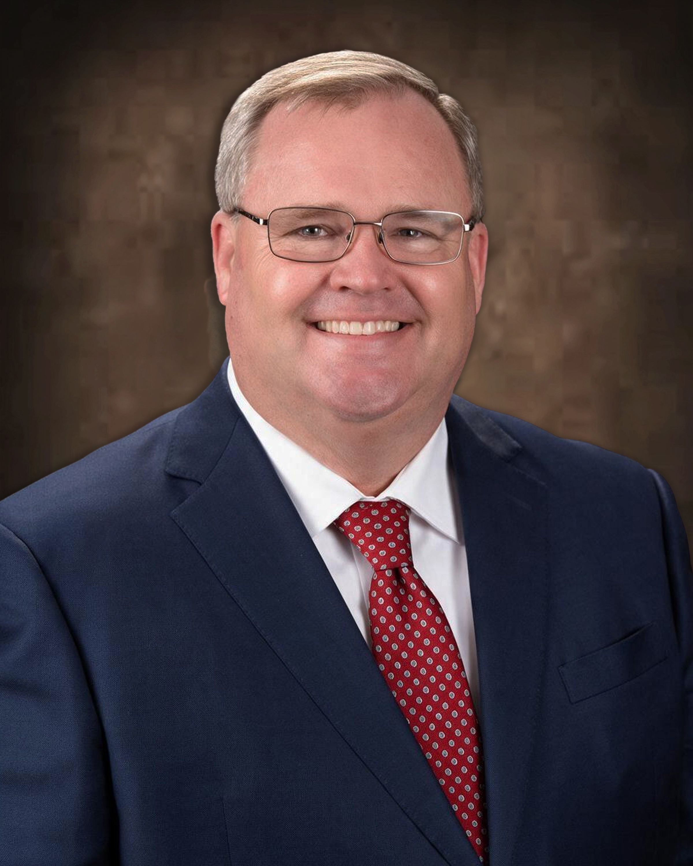 image of board member smiling with dark background