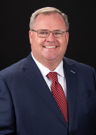 image of board member smiling with dark background