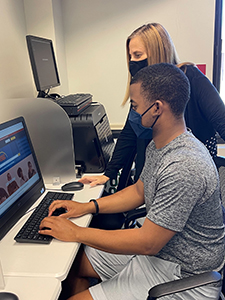 Zeek Blount sits at a computer beside Career Center & Alumni Development Coordinator Belinda Stephens to receive assistance with interest inventories, career exploration, resume building and interview preparation.