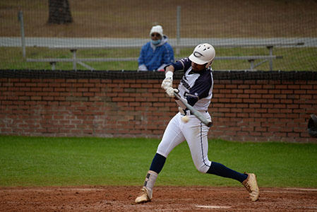A Chipola baseball player at bat swings at a pitch.