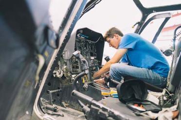 A man works on an airplane instrument panel