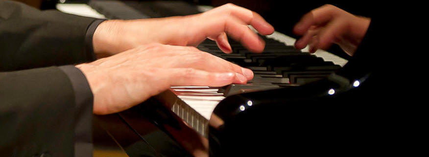 Close up of hands playing a piano